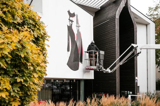 Vorschau Bild von Künstler Golif beim Gestalten der Almdudler
Hausfassade