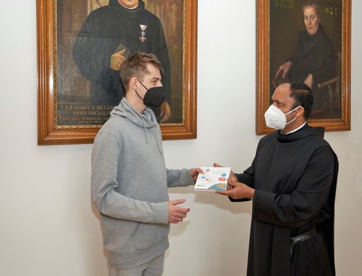 Pater Provinzial Saji Mullankuzhy überreicht in der
Provinzverwaltung der Barmherzigen Brüder ein Exemplar des Buches
"Kleine Gase – Große Wirkung: Der Klimawandel" an einen der 8.000
Mitarbeitenden.