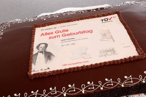 Vorschau Bild von TÜV AUSTRIA Group feiert zum Start von
#TÜVAUSTRIA150 im Jubiläumsjahr 2022 den Geburtstag ihres Gründers
Adam von Burg mit einer besonderen Sachertorte. Die Torte zeigt den
56-jährigen Adam von Burg in einer Lithographie Adolf Dauthages,
datiert 1853. Eine Montage von Ausschnitten eines Konstruktionsplans
eines "Circulations-Röhrenkessels System Dürr" aus dem Jahre 1890
entwickelt sich dezent zum #TÜVAUSTRIA150-Logo.