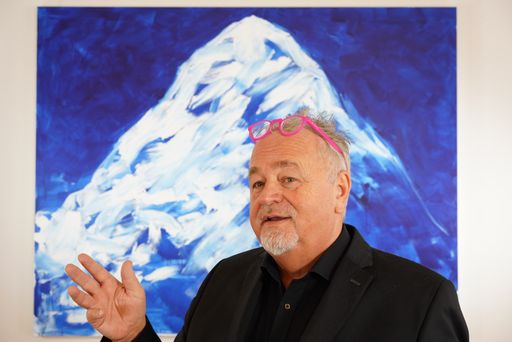 Veranstalter Helmut Reinisch vor einem Bild von
Herbert Brandl