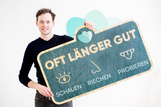 Vorschau Bild von Georg Strasser, Country Manager von Too Good To Go
Österreich, mit Oft Länger Gut-Zeichen als Holzschild