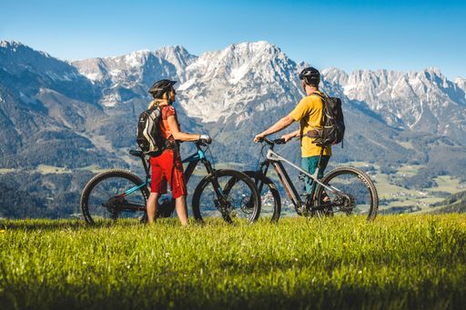 Zwei Menschen auf E-Bikes vor der Kulisse des
Wilden Kaisers.