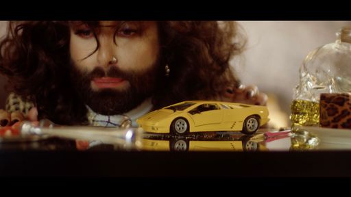 Vorschau Bild von Conchita Wurst mit der Spielzeug-Variante des
echten Lamborghini, mit dem er im neuen Musikvideo zu "CAR" durch
die Partynacht rauscht