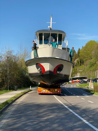 Vorschau Bild von Die komplett erneuerte MS Mondseeland wird am 29.
April 2022 mit Sondertransport durch den gesperrten Süden von
Mondsee zur Seepromenade transportiert, um wieder ins Wasser gekrant
zu werden. Die Schwertransporter der Firma Prangl musste dabei fast
einen Kilometer im Rückwärtsgang zurücklegen. Das Schiff hatte 60
Tonnen. Der spektakuläre Transport zog viele Schaulustige an und
verursachte einen Verkehrstau.