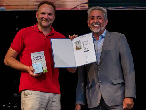  Ueberreuter Geschäftsführer Kommerzialrat Georg
Glöckler übergibt Thomas Stipsits die Auszeichnung "Platinbuch des
Hauptverbandes des Österreichischen Buchhandels" für mehr als 60.000
verkaufte "Eierkratz-Komplott".
