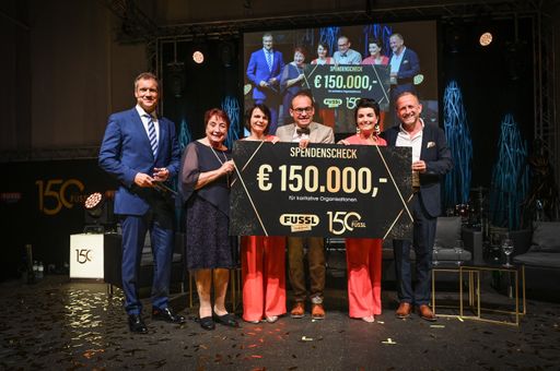 Vorschau Bild von 150 Jahre Fussl Modestraße, Armin Assinger, Familie Mayr mit
Spendenscheck