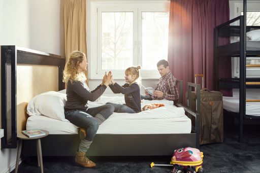 Eine Familie mit Kind im Zimmer eines a&o Hostels