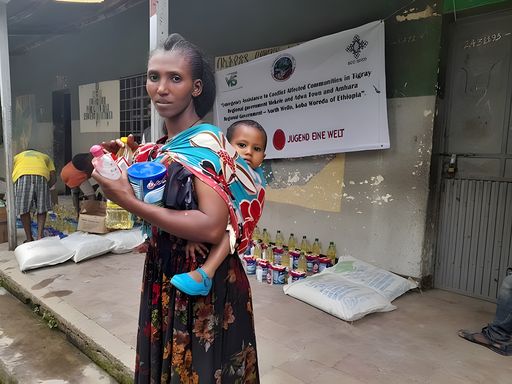 Frau mit Kind bei der Ausgabe der von Jugend Eine
Welt-Projektpartner überbrachten Hilfslieferungen in Kobo/Äthiopien