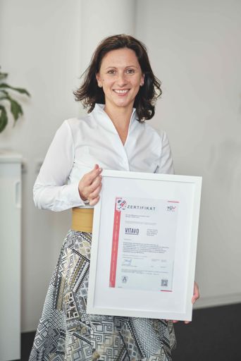 Vorschau Bild von VITAVO Geschäftsführerin Katharina Heil mit
Zertifikaten ISO 9001 und ISO/IEC 27001