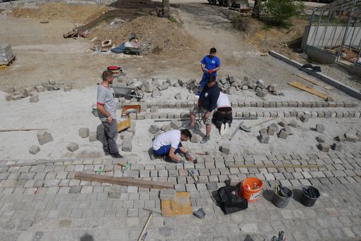 Vorschau Bild von Pflastererlehrlinge beim Arbeiten auf der Hoffläche
bei der VinziRast am Land