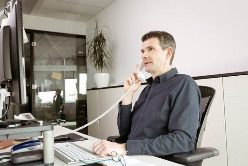 Mitarbeiter beim Telefonieren am Arbeitsplatz