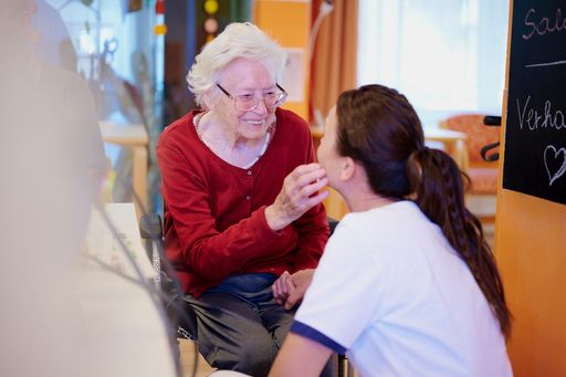Pflegerin mit Frau im Rollstuhl