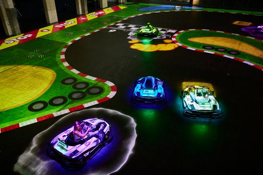 Auf einer Hallenfläche von 2.700m2 werden virtuelle
Erlebniswelten projiziert, wo Spieler selbst in sportlichen
Elektro-Karts aktiv werden.
