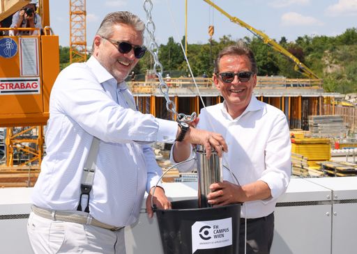 Stadtrat Peter Hacker und Wilhelm Behensky
übergeben eine Zeitkapsel, die im neuen House of Health Sciences
miteingebaut werden wird und an die symbolische Grundsteinlegung
erinnern soll.