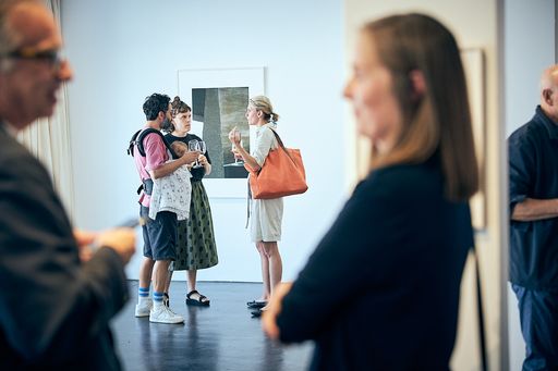  Besucher|innen in der Ausstellung.