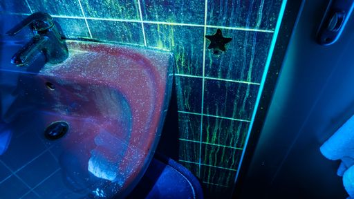 Vorschau Bild von Badezimmer unter dem Eindruck einer 365nm
Lichtquelle; gut sichtbar sind die Verunreinigungen durch
Körperflüssigkeiten