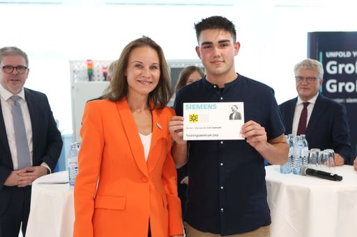 Vorschau Bild von Siemens Österreich CEO übergibt Auszubildenden
Moritz Hölzl die symbolische Schlüsselkarte zum neuen
Trainingszentrum