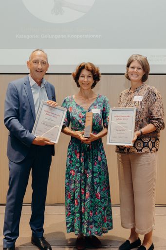 Günther Lutschinger (Verband für gemeinnütziges
Stiften) übergibt die Auszeichnung "Stifter*innen des Jahres:
Gelungene Kooperationen" an Julia Bogner (Verband der
Sparkassenstiftungen) und Birgit Radl-Wanko (younus).