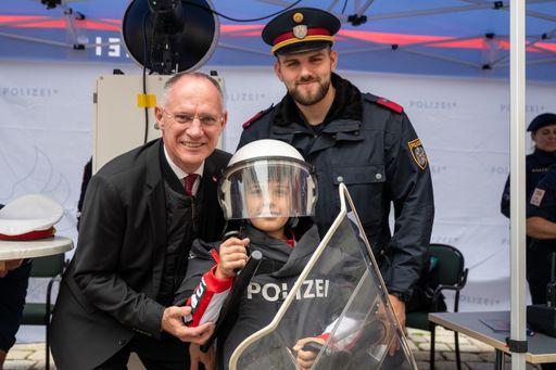 Innenminister Karner am "Tag der Polizei" mit einem
jungen polizeiinteressierten Besucher.