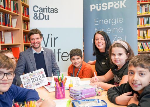 Vorschau Bild von Lukas Püspök – Geschäftsführer von PÜSPÖK (Mitte)
und Melanie Balaskovics – Caritas Direktorin, mit Kindern im Caritas
Lerncafé in Frauenkirchen.