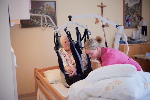Pflegeperson und Bewohnerin beim Transfer ins Bett