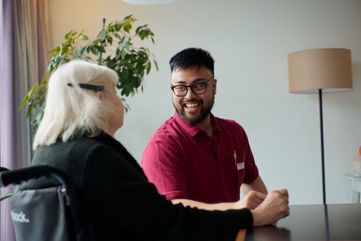 Vorschau Bild von Pfleger im Gespräch mit Bewohnerin