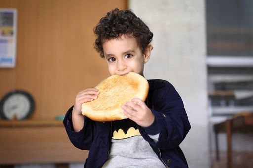 Rami, ein kleiner Bub aus Bethlehem, freut sich
über das kostenlose Brot, welches von den Jugend Eine
Welt-ProjektpartnerInnen in Bethlehem an notleidende Menschen
verteilt wird.