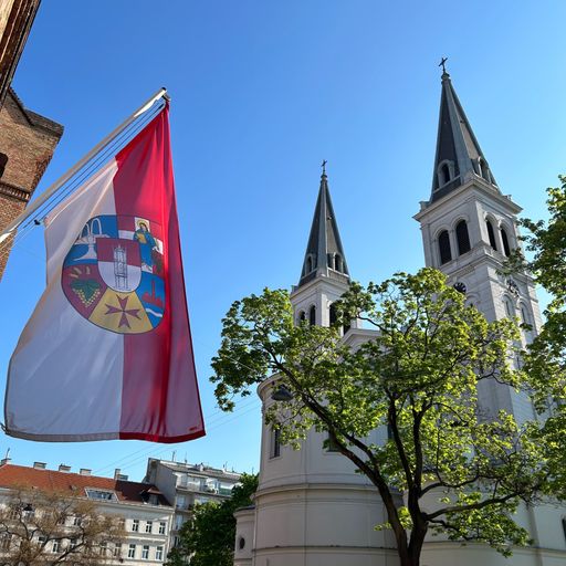  Die Kirche St. Johann Evangelist am Keplerplatz, links das
Bezirksamt mit Fahne, die das Bezirkswappen zeigt.