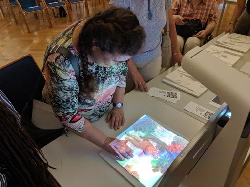 Workshop im Projekt BeauCoup: Eine Seniorin testet
den „Taktilen Multimedia Guide“ mit dem Bild „Der Vogeldieb“ von
Pieter Bruegel der Ältere.