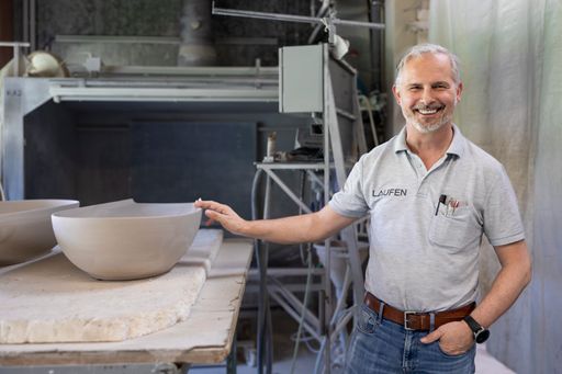 Vorschau Bild von Aufnahme aus dem LAUFEN Werk in Gmunden, OÖ. Ein
Mitarbeiter neben einem keramischen Rohstück (Waschtisch der
Kollektion ILBAGNOALESSI).