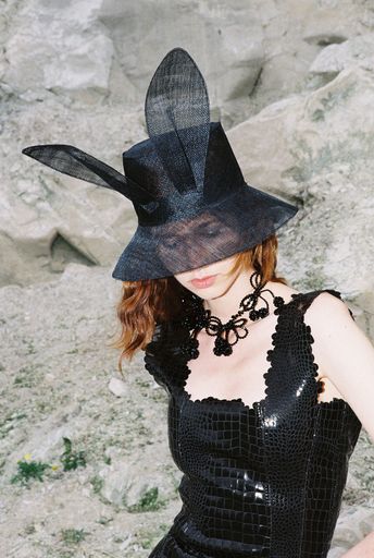 Florentina Leitner, Look aus der Kollektion Picnic
at Hanging Rock (Spring/Summer 2024), 2023 Hut aus Sinamay, Kette
aus Glasperlen (in Kooperation mit Helena Thulin), Kleid aus
Kunstleder mit Lasercut-Details
