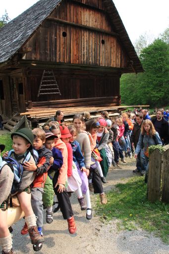 Vorschau Bild von Kinder sitzen am Maibaum, der vom Traktor ins
Museumstal geführt wird