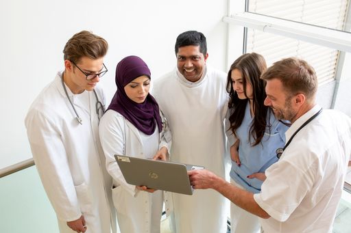 Mitarbeitende der Barmherzigen Brüder im Gespräch
vor einem Laptop