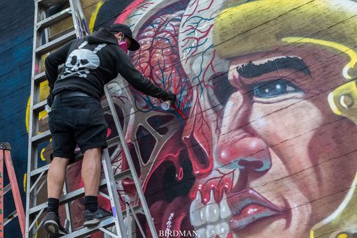 Künstler Nychos bei der Erstellung eines Murals.