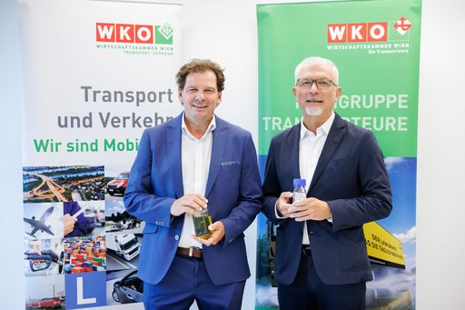 Wolfgang Böhm, Obmann der Fachgruppe Transporteure
in der Wirtschaftskammer Wien, und Davor Sertic, Obmann der Sparte
Transport und Verkehr in der WK Wien, zeigen ein Glas mit
herkömmlichen Diesel und dem farblosen HVO 100.