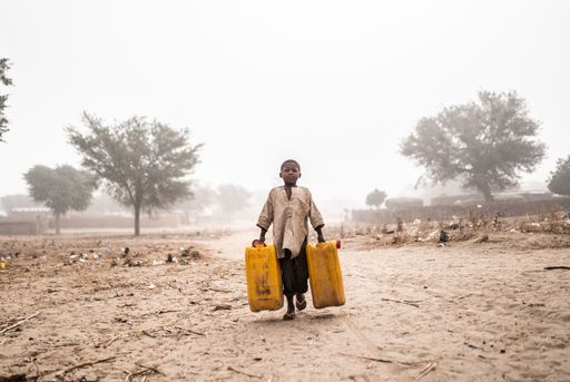 BILD zu OTS Frühmorgens, bedeckt von Staub und Wind, holt ein
Kind Wasser an der nächstgelegenen Wasserstelle im 15 Kilometer
entfernten Dorf Tchadi nahe der Grenze zwischen Niger und Nigeria.