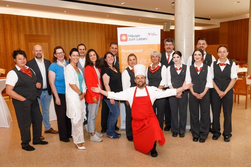 Vorschau Bild von „Unser Restaurant ‚Zum Augenblick‘ unterscheidet
sich deutlich von herkömmlichen Restaurants, weil es ganz konkret
auf diese Zielgruppe abgestimmt ist. Neben speziell geschultem
Servicepersonal steht auch Pflegepersonal für etwaige Unterstützung
und Betreuung zur Verfügung. Die Speisen sind auf unsere
Bewohner*innen abgestimmt und können, etwa bei Kau- und
Schluckbeschwerden, auch als gemixte Kost geordert werden“,
erläutert Robert Guschelbauer (links), Bereichsleiter
Gastronomisches Management der Häuser zum Leben. Bemerkenswert ist,
dass hier Expert*innen aus unterschiedlichen Bereichen der Häuser
zum Leben, wie etwa aus der Pflege und Betreuung, der Diätologie und
aus der Küche an diesem Projekt zusammenarbeiteten. Am Erfolg des
Restaurants „Zum Augenblick“ sind auch die Forschungsküche der
Häuser zum Leben mit ihrer Expertise und Lehrlinge des
gastronomischen Bereichs mit ihrem Arbeitseinsatz maßgeblich
beteiligt. In der Mitte: Küchenchef Günter Hymer gemeinsam mit dem
Projekt- und Service-Team.