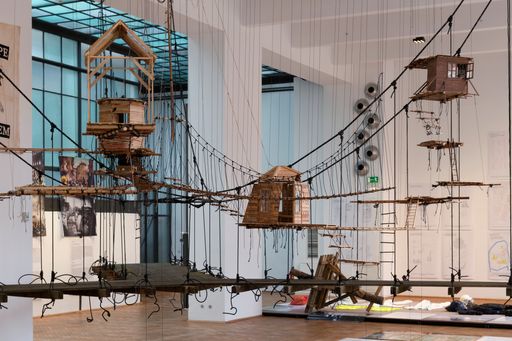 MAK Ausstellungsansicht, 2024; "PROTEST/ARCHITEKTUR. Barrikaden,
Camps, Sekundenkleber" im Vordergrund: Stephan Mörsch: „Beechtown“,
1:10-Modell der Baumhaussiedlung Beech town im Hambacher Wald,
2018–2023 im Hintergrund: Hängebrücke, Oaktown, Hambacher Wald,
2019−2023