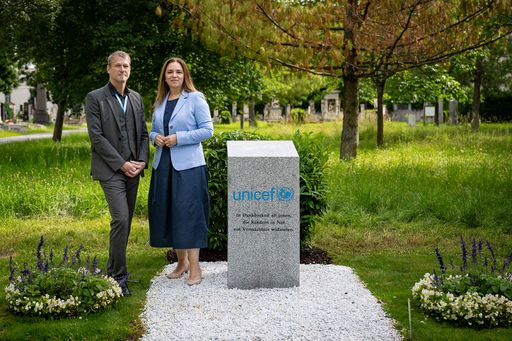 Christoph Jünger, Geschäftsführer von UNICEF Österreich und
Renate Niklas, Geschäftsführerin der Friedhöfe Wien GmbH stehen
neben dem UNICEF Gedenkstein.