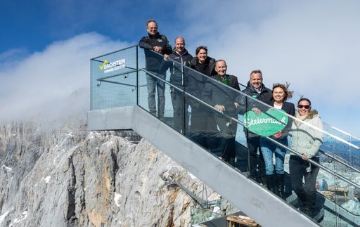 Vorschau Bild von 7 Personen Himmelsleiter von links: Georg Bliem (GF
Planai-Hochwurzen-Bahnen), Mathias Schattleitner (GF
Schladming-Dachstein/Präs. dna Austria), Astrid Steharnig-Staudinger
(GF ÖW), Ernst Fischbacher (Bürgermeister Ramsau am Dachstein),
Michael Feiertag (GF STG), Staatssekretärin Susanne Kraus-Winkler,
Ulrike Rauch-Keschmann (Bundesministerium für Arbeit und Wirtschaft)