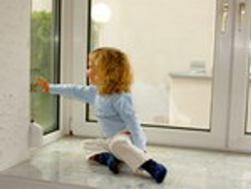 Kleines Kind greift auf Fenster mit Kondenswasser