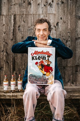  Thomas Heribert Klein mit Almdudler-Comic und Almdudler
Formflaschen im Comic-Design