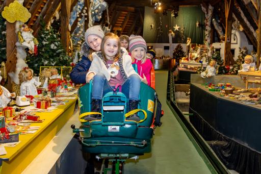 Vorschau Bild von In Schienengondeln fährt man über drei Etagen bis in die
Engelwerkstatt im Dachgeschoß.