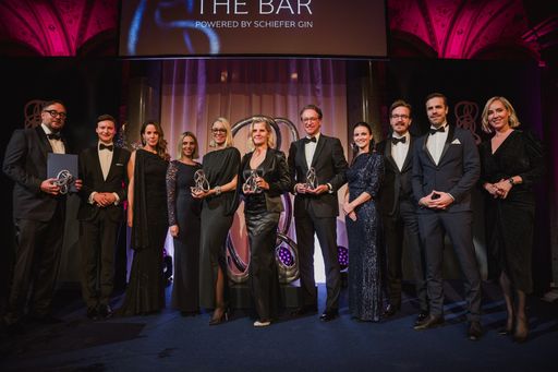  Die Preisträger:innen der Schiefer Awards, Keynote-Speakerin
Natalie Amiri, Gastgeber Martin Schiefer sowie Moderatorin Nadja
Bernhard auf der Bühne.