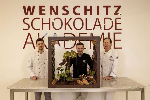  Johannes Warmuth mit seinem preisgekrönten Schaustück vom Central
Europe Chocolate Master – eine atemberaubende Kreation aus 100 %
Schokolade zum Thema „Play“, inspiriert vom Schönbrunner Tiergarten,
mit Fokus auf Chamäleons. Präsentiert in der Schokoladenwelt von
Maître Chocolatier Helmut Wenschitz in Allhaming, Oberösterreich,
gemeinsam mit Helmut Wenschitz und seinem Sohn Christoph Wenschitz.