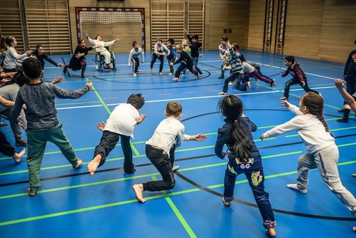 Vorschau Bild von Die Kinder einer Schulklasse laufen in einem Kreis energetisch
aufeinander zu.