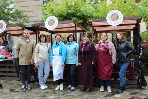 Marktstand ukrainischer Frauen. Davor Gruppe von Teilnehmerinnen
am Projekt "Schlüsselwege aus der Armut" mit betreuenden
Sozialarbeiterinnen (ganz li: Yuriy Lopatynskyy, Geschäftsführer
Walnusshaus)