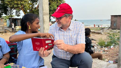 Jugend Eine Welt-Geschäftsführer Reinhard Heiserer mit einer
Schülerin des von Jugend Eine Welt unterstützten Bildungsprojekts
„Beach Blossom“. Am Strand der südostindischen Millionenstadt
Vishakhapatnam werden fünf- bis achtjährige Kinder aus
benachteiligten Familien – oft sind ihre Eltern Wanderarbeiter oder
Fischer – mit Aufbau- und Weiterbildungskursen für den Besuch einer
staatlichen Schule vorbereitet.