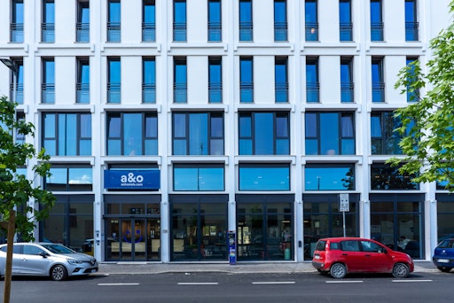 Vorschau Bild von Fassade des neuen a&o Hostel Florenz Campo di Marte mit viel Glas
und hellen Wänden.