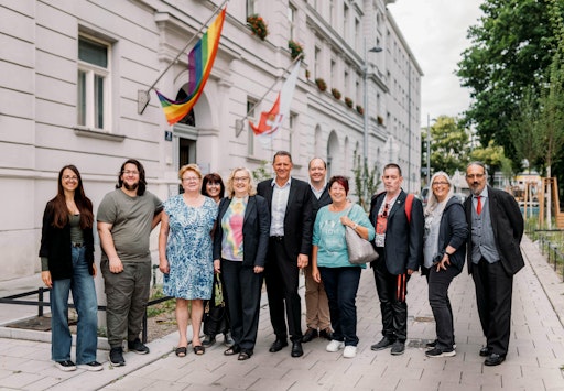 Vorschau Bild von Zivilgesellschaftliche Initiativen begrüßen die Hissung der
Regenbogenfahne vor dem Amtsgebäude in Simmering.